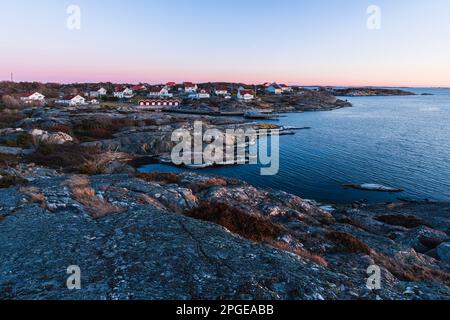 La photo montre un magnifique coucher de soleil sur le port d'une ancienne cabine suédoise de bord de mer, entouré par l'architecture étonnante. Banque D'Images