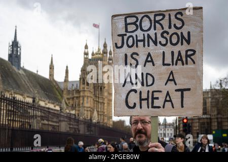 Londres, Royaume-Uni. 22 mars 2023. Un homme avec un signe à l'extérieur du Parlement comme Boris Johnson, ancien Premier ministre, donne des preuves au Comité des privilèges au sujet du scandale de Partygate. Credit: Stephen Chung / Alamy Live News Banque D'Images