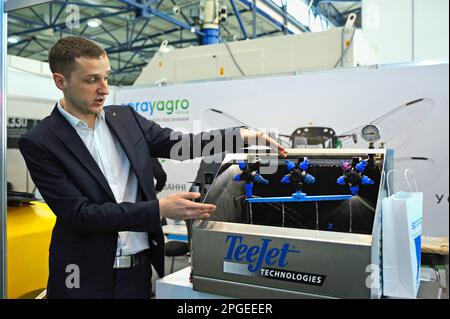 Homme responsable des ventes démontrant la buse de pulvérisation d'une machine de fertilisation liquide travaillant sur support. Exposition exposition exposition AGROTRADE. Kiev, Ukraine Banque D'Images