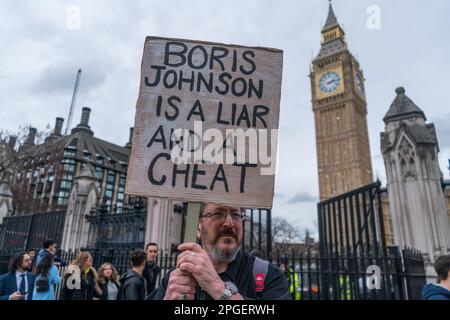 Londres, Royaume-Uni 22 mars 2023. Un manifestant détient un signe contre l'ancien Premier ministre Boris Johnson, lui faisant passer le nom de triche et de menteur, alors qu'il dénombre aujourd'hui un Comité des privilèges spécial de la Chambre des communes après avoir admis qu'il a induit en erreur les députés sur Partygate à Downing Street, mais pas sur son objectif. Credit: amer ghazzal / Alamy Live News Banque D'Images