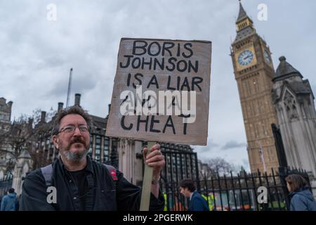 Londres, Royaume-Uni 22 mars 2023. Un manifestant détient un signe contre l'ancien Premier ministre Boris Johnson, lui faisant passer le nom de triche et de menteur, alors qu'il dénombre aujourd'hui un Comité des privilèges spécial de la Chambre des communes après avoir admis qu'il a induit en erreur les députés sur Partygate à Downing Street, mais pas sur son objectif. Credit: amer ghazzal / Alamy Live News Banque D'Images