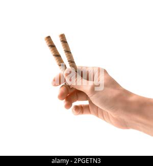 Rouleaux de cachets en mains sur isolation. La fille tient des gaufres croustillantes dans ses mains sur un fond blanc gros plan. Dessert croustillant avec garniture au chocolat. W Banque D'Images