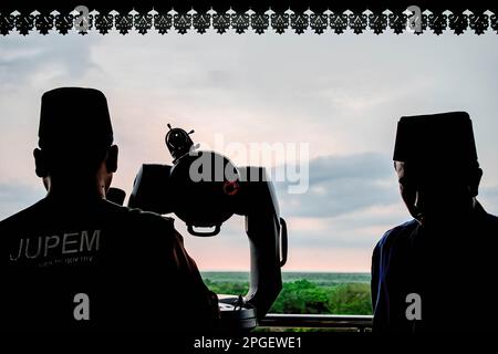 Kuala Selangor, Malaisie. 22nd mars 2023. Silhouette de deux officiels du Conseil religieux islamique Selangor lors d'une ''rukyah'', une cérémonie d'observation de la lune pour déterminer la date de début du mois Saint du Ramadan à Bukit Malawati. (Credit image: © Syairful Redzuan/SOPA Images via ZUMA Press Wire) USAGE ÉDITORIAL SEULEMENT! Non destiné À un usage commercial ! Banque D'Images