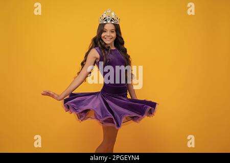 Robe venteuse mouvement. Petite reine portant une couronne dorée. Adolescente princesse tenant tiara couronne. PROM partie, concept d'enfance. Bonne fille visage Banque D'Images