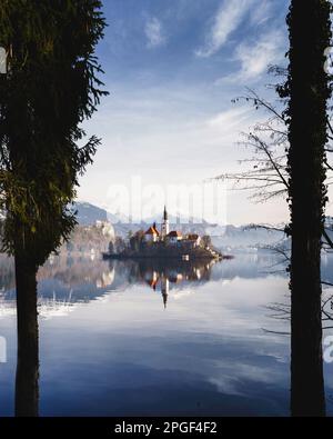 Une vue panoramique sur un lac Bled en Slovénie avec une église visible à travers les arbres en arrière-plan Banque D'Images