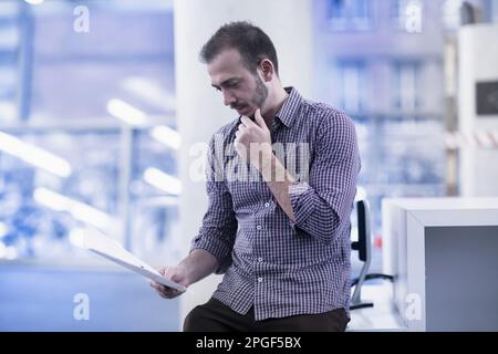 Jeune architecte regardant un plan dans un bureau, Freiburg im Breisgau, Bade-Wurtemberg, Allemagne Banque D'Images