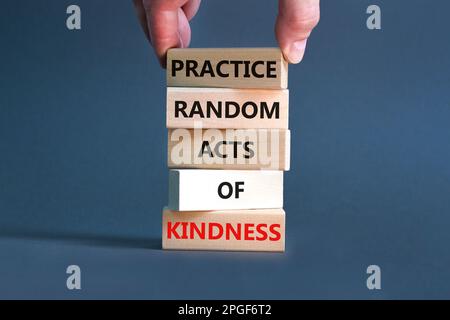 Pratiquer le type aléatoire de symbole de bonté. Concept mots pratique aléatoire genre de bonté sur bloc de bois. Magnifique fond gris. Main d'homme d'affaires. Banque D'Images