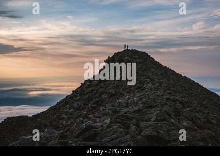 Deux randonneurs se tiennent sur le sommet de Katahdin, Maine à l'aube. Silhouette. Banque D'Images