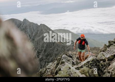 Les randonneurs marchent sur un sentier rocheux au-dessus des nuages de Katahdin, Maine Banque D'Images