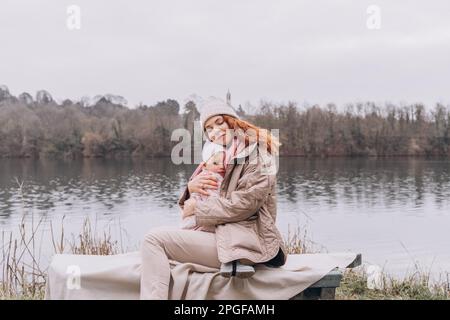 Maman et bébé maussettes sont assis dans un parc brumeux au bord de la rivière Banque D'Images