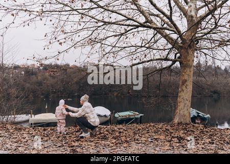 Un père et une fille, deux ans, marchent près de la rivière au printemps Banque D'Images