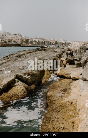 Vagues s'écrasant sur de grands rochers sur une plage de Malte Banque D'Images
