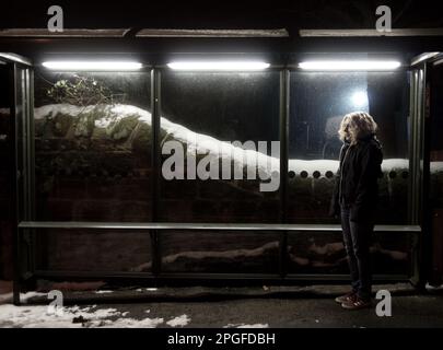 image couleur d'une femme en attente à un bustop en hiver Banque D'Images