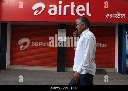 Un homme communiquant sur un téléphone portable passe devant le magasin Airtel de Mumbai. Airtel offre des données illimitées à ses 5G clients dans 26 villes. Elle couvrira l'ensemble des utilisateurs du pays, des zones rurales et urbaines d'ici la fin de mars 2024. Banque D'Images