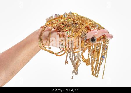 Photo horizontale de la main d’une femme tenant des bijoux en or isolés sur du blanc. Banque D'Images