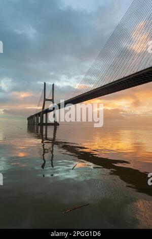 Arrière-plan avec lever de soleil coloré sur le pont de Lisbonne. Le pont Vasco da Gama est un point de repère, l'un des plus longs ponts du monde. Paysage urbain Banque D'Images