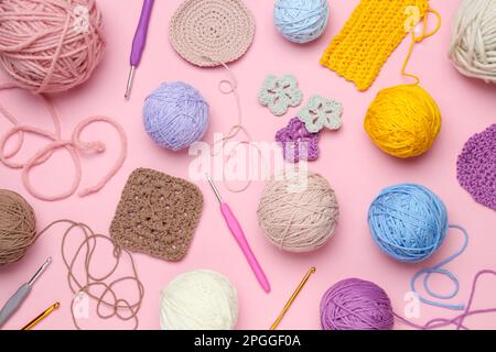 Composition de pose plate avec fils à tricoter et crochets en crochet sur fond rose Banque D'Images