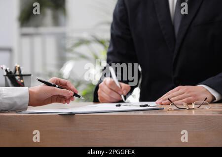 Femme lisant le document à la table dans le bureau, fermer. Signature du contrat Banque D'Images