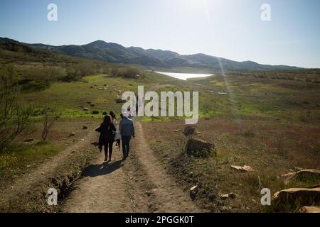 On voit des militants de l'environnement et des droits de l'homme marcher vers le réservoir avant de participer à une manifestation contre le changement climatique, organisée par Amnesty International. Pour marquer la Journée internationale de l'eau, des militants d'Amnesty International, ainsi que plusieurs organisations environnementales, ont dénoncé le changement climatique et ses effets sur les droits de l'homme dans le monde entier par une performance qui représente la mort symbolique du réservoir de la Viñuela. Le réservoir de Viñuela, qui fournit de l'eau aux municipalités situées près de la région d'Axarquia, est à un niveau d'eau minimal en raison de la grave boiteuse Banque D'Images