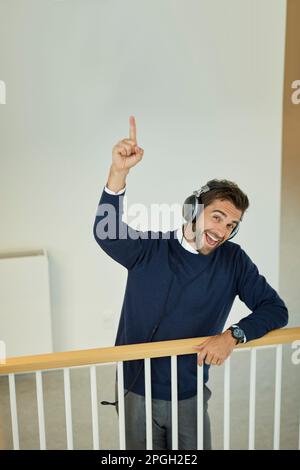 Avez-vous entendu les dernières nouvelles. Portrait d'un jeune homme d'affaires portant un casque et pointant vers le haut dans un bureau. Banque D'Images