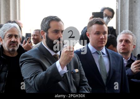 New York, États-Unis. 22nd mars 2023. Jacob Garlick (avant, l), le soumissionnaire numéro 2, un employé d'un fonds d'investissement, offre sur le bâtiment triangulaire Flatiron à la vente aux enchères. Après une guerre d'enchères d'une durée d'environ une heure sur les marches devant un palais de justice de Manhattan, Garlick a gagné les enchères à une somme de $190 millions (environ 175 millions d'euros). Le « Flatiron Building » est l'un des sites les plus populaires de New York. Credit: Christina Horsten/dpa/Alay Live News Banque D'Images