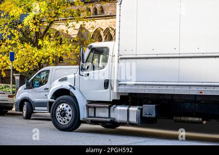 Un semi-camion industriel à cabine de jour avec remorque à plateau et mini-fourgonnette permet aux clients de se tenir debout sur la rue accordi de la ville Banque D'Images