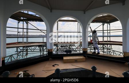 PRODUCTION - 22 mars 2023, Saxe, Großpösna: Le maître peintre Jürgen Lenz peint les arches de l'église flottante en échafaudage 'Vineta' sur le lac Störmthal. Après une bonne décennie sur l'eau et le vent et le temps durables, la façade doit être renouvelée et peinte. La Vineta n'est pas une église consacrée, mais sa tour de 15 mètres de haut est calquée sur le clocher de l'ancienne église de Magdeborn. Le village de Magdeborn était l'un des nombreux endroits qui ont dû céder la place à l'extraction de lignite à ciel ouvert. Le lac Störmthal a été créé par l'inondation de la mine. Concerts, lectures ou célébrations privées telles que mariage céré Banque D'Images