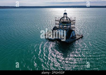 PRODUCTION - 22 mars 2023, Saxe, Großpösna: Vue de l'église flottante en échafaudage 'Vineta' sur le lac Störmthal. Après une bonne décennie sur l'eau et le vent permanent et le temps, la façade doit être renouvelée et peinte. La Vineta n'est pas une église consacrée, mais sa tour de 15 mètres est calquée sur le clocher de l'ancienne église de Magdeborn. Le village de Magdeborn était l'un des nombreux endroits qui ont dû céder la place à l'extraction de lignite à ciel ouvert. Le lac Störmthal a été créé par l'inondation de la mine. Des concerts, des lectures ou des célébrations privées telles que des cérémonies de mariage ont lieu sur la Vineta. (À dpa : « T Banque D'Images