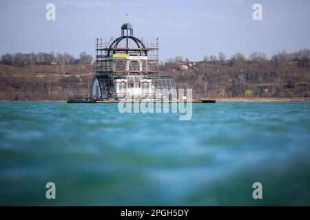 PRODUCTION - 22 mars 2023, Saxe, Großpösna: Vue de l'église flottante en échafaudage 'Vineta' sur le lac Störmthal. Après une bonne décennie sur l'eau et le vent et le temps durables, la façade doit être renouvelée et peinte. La Vineta n'est pas une église consacrée, mais sa tour de 15 mètres est calquée sur le clocher de l'ancienne église de Magdeborn. Le village de Magdeborn était l'un des nombreux endroits qui ont dû céder la place à l'extraction de lignite à ciel ouvert. Le lac Störmthal a été créé par l'inondation de la mine. Des concerts, des lectures ou des célébrations privées telles que des cérémonies de mariage ont lieu sur la Vineta. (À dpa : « TH Banque D'Images