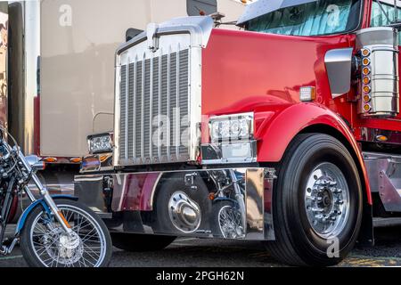 Tracteur semi-remorque industriel américain robuste, grand poids, rouge, avec vélo passe-temps classique, debout sur le parkin marqué de l'arrêt de camion Banque D'Images