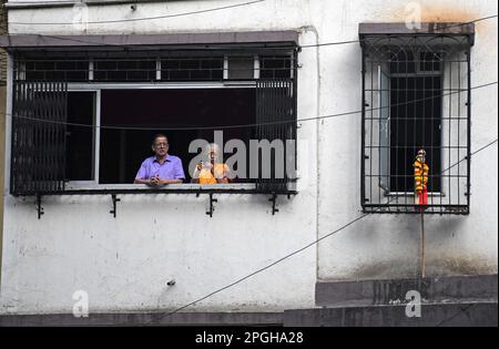 Mumbai, Inde. 22nd mars 2023. Un couple debout sur le balcon de leur maison regarde une procession Gudi Padwa à Mumbai. Gudi Padwa est le premier jour de la nouvelle année célébrée par les Maharashtrians et les Hindous Kokani, qui marque les nouveaux débuts et l'arrivée de la saison de printemps. Crédit : SOPA Images Limited/Alamy Live News Banque D'Images