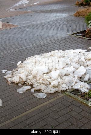 Un tas de neige et de morceaux de glace fondues au coin d'un parking Suffolk Banque D'Images
