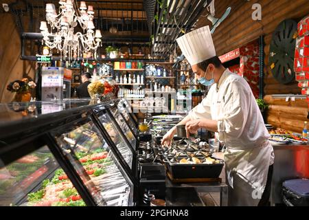 Manzhouli, région autonome de la Mongolie intérieure de la Chine. 15th mars 2023. Un chef cuisinait dans un restaurant russe à Manzhouli, dans la région autonome de Mongolie intérieure de Chine du nord, à 15 mars 2023. La popularité des produits et des aliments russes a repris chez les clients locaux après la reprise des services du port terrestre de Manzhouli. Credit: BEI HE/Xinhua/Alay Live News Banque D'Images