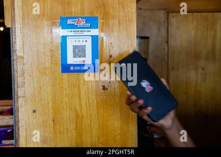 Main tenant le téléphone mobile au code QR pour le paiement sans espèces dans le café Poetry de Trichy, Tamil Nadu, Inde Banque D'Images