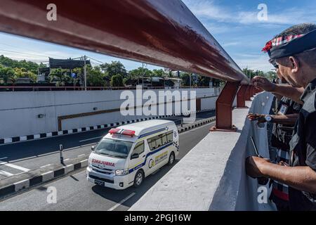 Badung, Indonésie. 22nd mars 2023. Les gardes de sécurité traditionnels de Bali, connus localement sous le nom de Pecalang, regardent le passage d'urgence en ambulance dans la rue le jour de Nyepi. Bali célèbre Nyepi, ou le jour du silence, sur lequel ils ne travaillent pas, ne pas allumer les lumières, ne pas voyager, et ne vous laissez pas tenter par des indulgences, pour marquer le nouvel an hindou balinais Saka, qui tombe sur 22 mars 2023. (Photo de Dicky Bisinglasi/SOPA Images/Sipa USA) crédit: SIPA USA/Alay Live News Banque D'Images