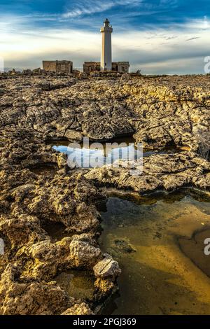 Les rochers, les flaques d'eau de mer et le vieux phare de la réserve naturelle de Plemmirio. Syracuse, Sicile, Italie Banque D'Images