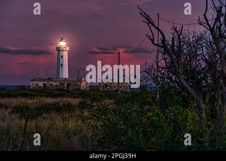 Le phare de Capo Murro di Porco s'illumina au coucher du soleil. Aire marine protégée de Plemmirio dans la péninsule de Maddalena. Syracuse, Sicile, Italie Banque D'Images