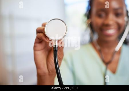 Gros plan sur le stéthoscope du médecin avec une femme souriante en arrière-plan Banque D'Images