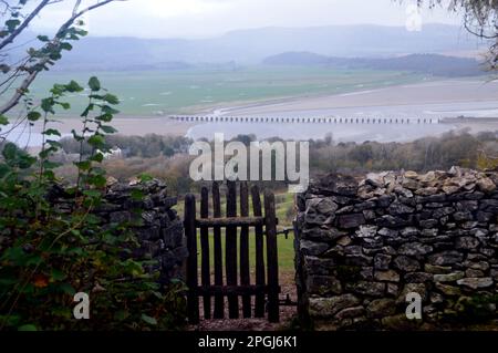 Porte en bois dans le mur de pierre menant vers le bas à Red Hills Wood d'Arnside Knott à Arnside, Cumbria, Angleterre, Royaume-Uni. Banque D'Images