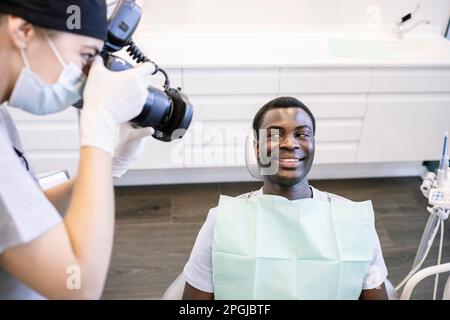 Dentiste photographiant les dents du patient à l'aide d'un appareil photo dans une clinique médicale Banque D'Images