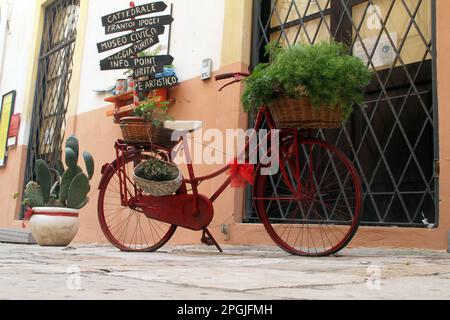 Vélo décoratif en face du centre d'information touristique, avec des flèches pointant vers différentes attractions à Gallipoli, Italie Banque D'Images