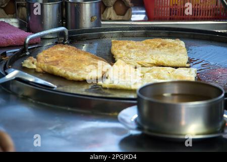 Roti dans une poêle à frire profonde, arrosée de sucre granulé et de lait concentré sucré Banque D'Images