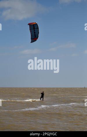 Kite surfeur embrassant les conditions venteuses à Martello Bay Clacton sur Sea Essex Royaume-Uni. Banque D'Images