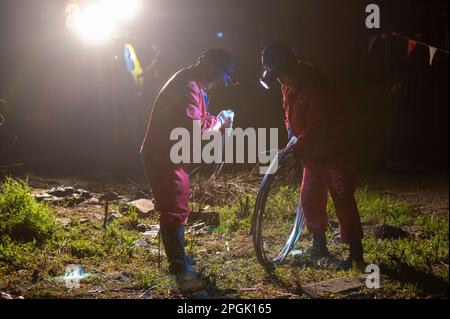 ZHENJIANG, CHINE - LE 22 MARS 2023 - les travailleurs de l'électricité font braver la pluie pour modifier le fil de masse de la Zhenline 5 de 220 kV traversant le chemin de fer à grande vitesse Banque D'Images