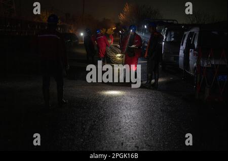 ZHENJIANG, CHINE - LE 22 MARS 2023 - les travailleurs de l'électricité font braver la pluie pour modifier le fil de masse de la Zhenline 5 de 220 kV traversant le chemin de fer à grande vitesse Banque D'Images