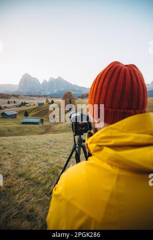 Vue arrière verticale d'un photographe professionnel prenant des photos d'une montagne sur un trépied Banque D'Images