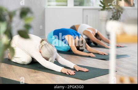 Professeur de yoga adulte montrant d'autres poses de yoga dans le centre de bien-être Banque D'Images