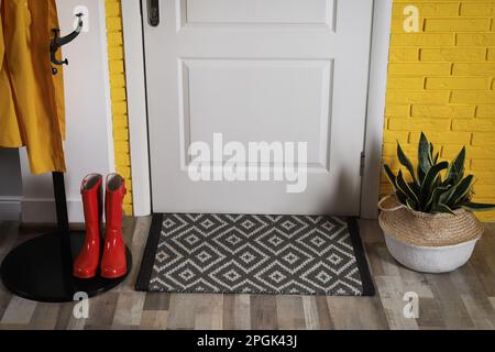 Intérieur de couloir avec belle maison, support de suspension et tapis de porte sur le sol près de l'entrée Banque D'Images