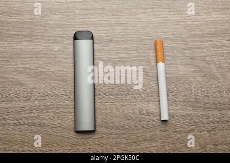 Cigarettes et dispositif de vapotage sur fond en bois, plat. Alternative fumeurs Banque D'Images