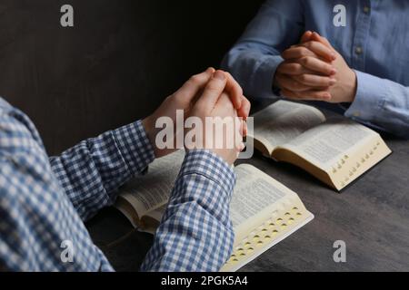 Couple priant au-dessus des Bibles à la table grise, fermer Banque D'Images